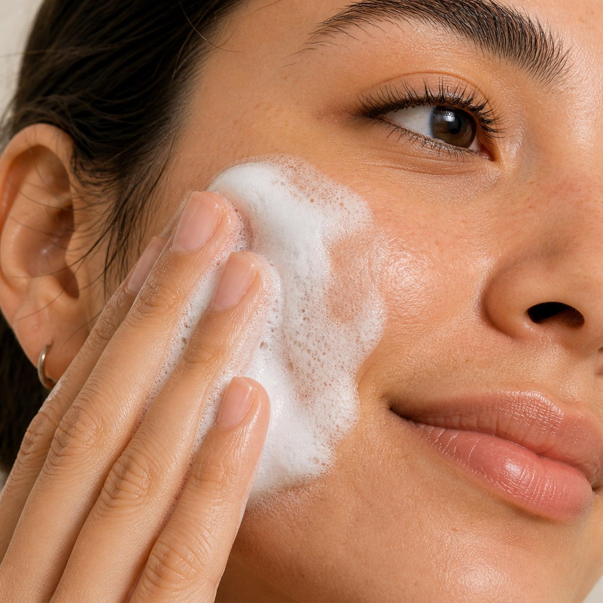 Mujer aplicando limpiador suave en su rostro, ideal para piel sensible y rutina personalizada